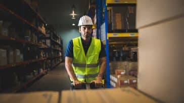 handsome young male employee concentrating and focusing on work wearing safety helmet